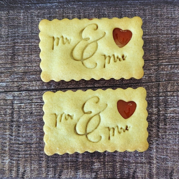 Two rectangular Wedding Jam Biscuits embossed with "Mr & Mrs" and a heart-shaped jam centre.