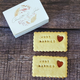 Personalised Wedding Favours: Two rectangular biscuits with "Just Married" embossed and a heart-shaped jam centre, presented in a gift box with the names "Charlotte & John".