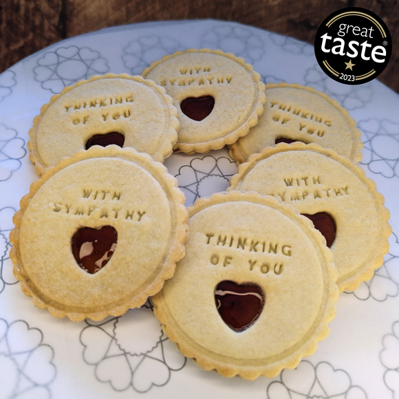 Cookies with 'Thinking of You' and 'With Sympathy' text on a decorative plate.