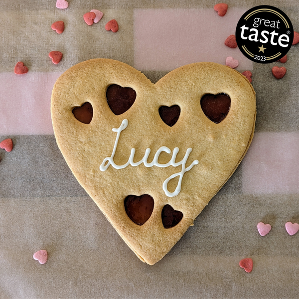 A heart-shaped cookie with the name "Lucy" written on it  for Valentine's day