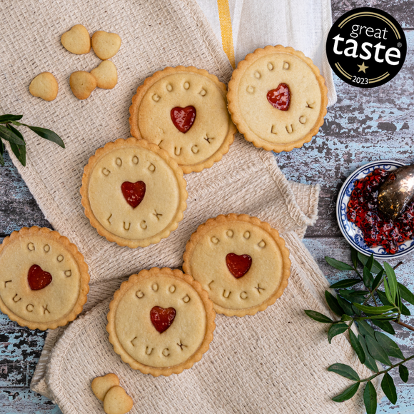 A stack of heart-shaped biscuits with jam filling, on a table