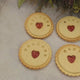 Close-up view of branded jam biscuits from The Biskery company with 'WELCOME', 'BABY', and a personalised name messages