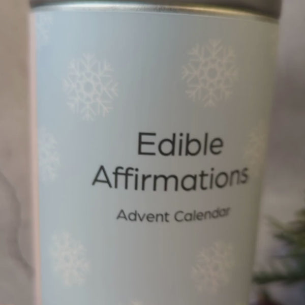 Video with a tin labelled  'Edible affirmation advent calendar' sitting on a table, filled with affirmation biscuits 