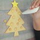  In the video, a person is decorating a Christmas tree using a special DIY biscuits kit from The Biskery Company.