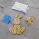 Cookie DIY Kit: White bunny-shaped cookie with white icing, next to sprinkles and sugar.