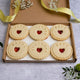 Jam impressed birthday biscuits. A letterbox of birthday jam biscuits. The biscuits are decorated with the words "Happy Birthday" and a personalised name. They are heart-shaped and filled with jam