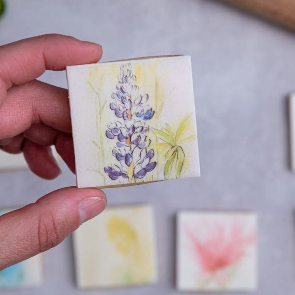 Woman holding a small flower biscuit.