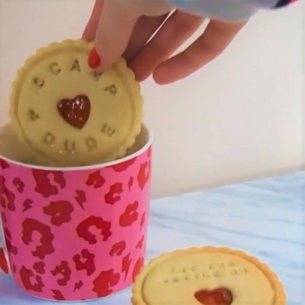 Dunking an impressed jam biscuit in a hot brew